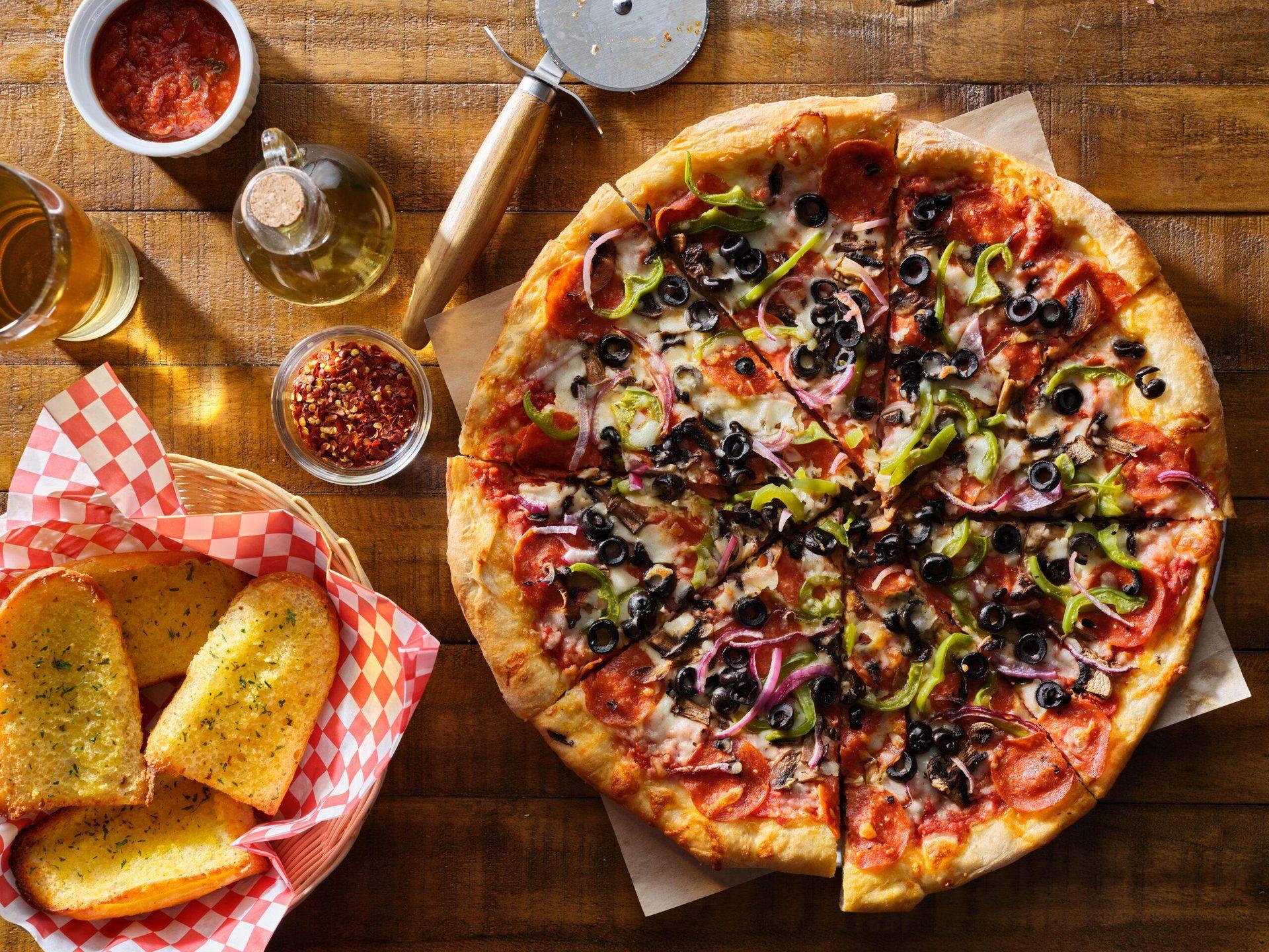 Salami-Pizza mit schwarzen Oliven und Peperoni